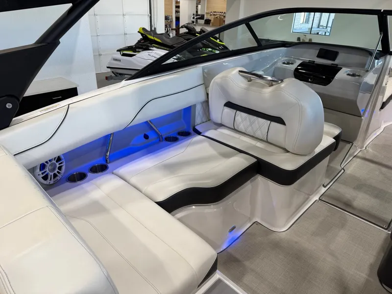 Slide: The Image of The image shows the interior of a 2022 Regal LS2 Surf boat with white leather seats and blue lighting. - 16