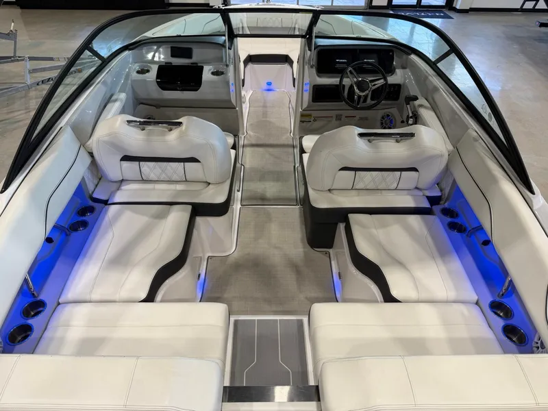 Slide: The Image of The image shows the interior of a 2022 Regal LS2 Surf boat with white seating and blue lighting. - 15