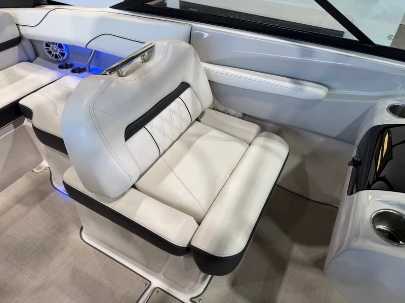 Slide: The Image of The interior of a 2022 Regal LS2 Surf with sleek white upholstered seats and blue accents. - 20