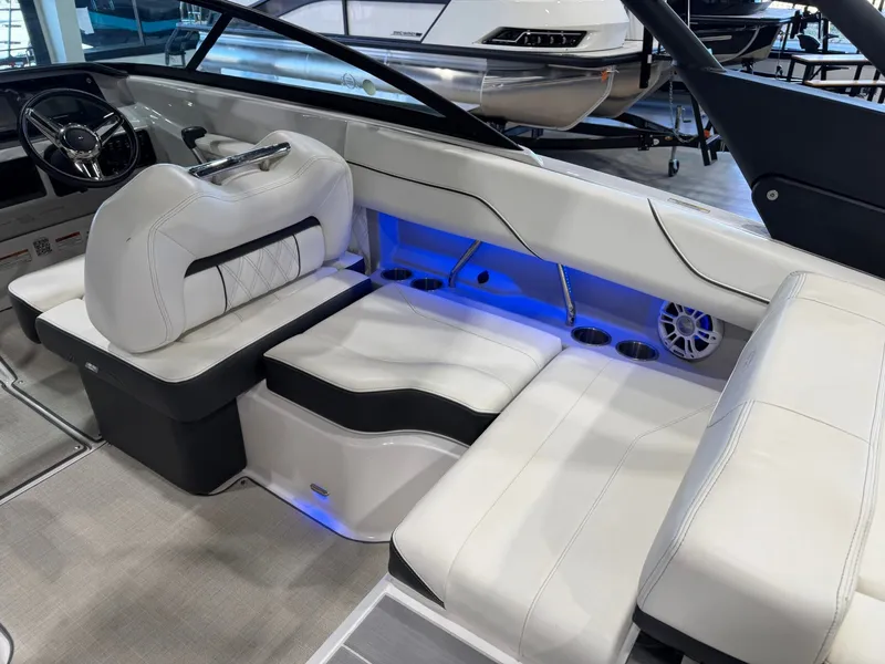 Slide: The Image of The image shows the interior of a 2022 Regal LS2 Surf boat with white upholstery and blue lighting. - 17