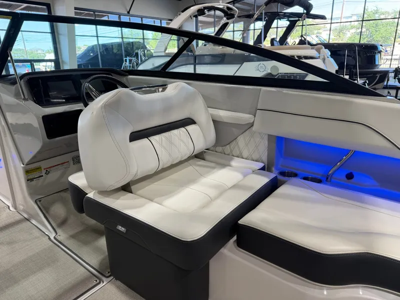 Slide: The Image of The image shows the interior of a 2022 Regal LS2 Surf boat with white upholstery and blue lighting. - 19