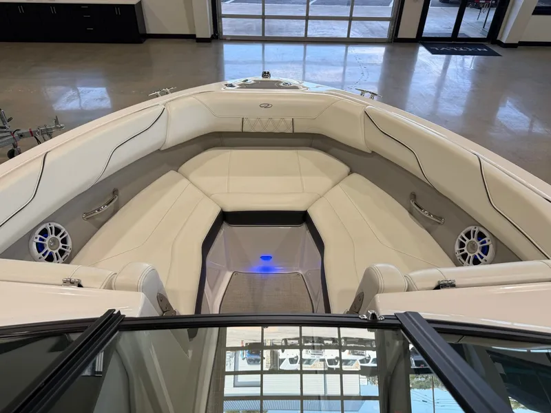 Slide: The Image of The image shows the bow of a 2022 Regal LS2 Surf boat with white upholstery. - 27