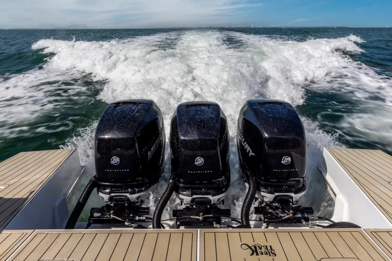 Slide: The Image of Triple Mercury outboard engines powering a 2021 Cruisers Yachts 42 GLS OB on open water. - 24