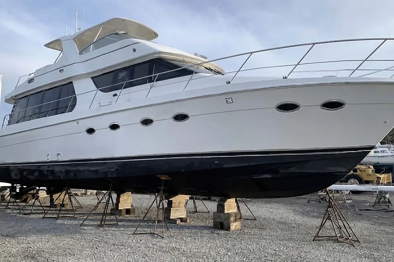 Slide: The Image of 2004 Carver 570 Voyager Pilothouse yacht on stands, showcasing sleek design and spacious structure. - 2