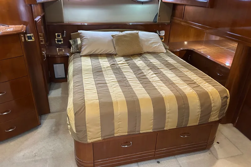 Slide: The Image of Luxurious bedroom interior of 2004 Carver 570 Voyager Pilothouse yacht with striped bedding. - 15