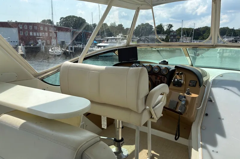 Slide: The Image of Pilothouse interior of 2004 Carver 570 Voyager, featuring helm and seating, dockside view. - 8