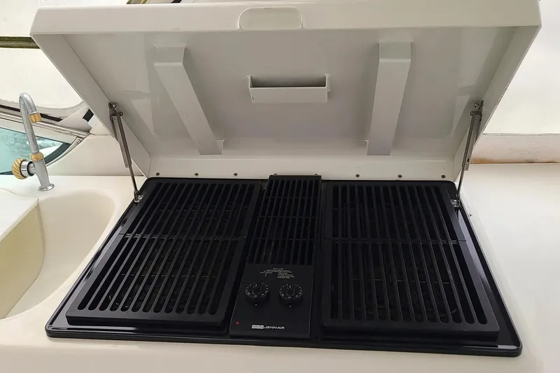Slide: The Image of Outdoor grill on 2004 Carver 570 Voyager Pilothouse yacht, featuring dual burners and protective lid. - 9