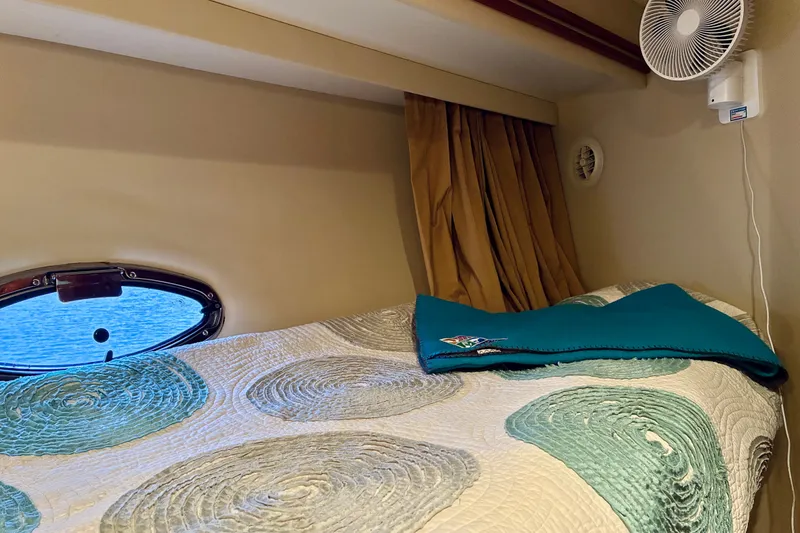 Slide: The Image of Cozy cabin interior of 2004 Carver 570 Voyager Pilothouse with bed, porthole, and fan. - 34
