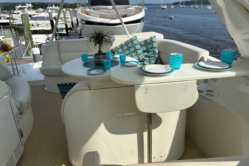 Slide: The Image of Luxurious 2004 Carver 570 Voyager Pilothouse yacht with elegant outdoor dining setup. - 6