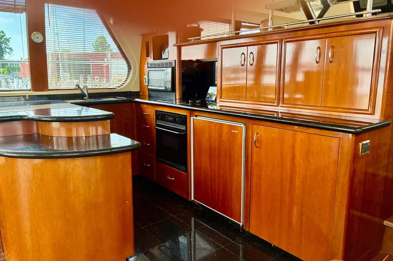 Slide: The Image of Luxurious kitchen interior of 2004 Carver 570 Voyager Pilothouse with wood cabinetry and modern appliances. - 11