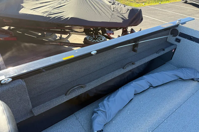 Slide: The Image of 2026 Crestliner 2050 Commander Elite boat interior with storage compartment and covered equipment. - 11