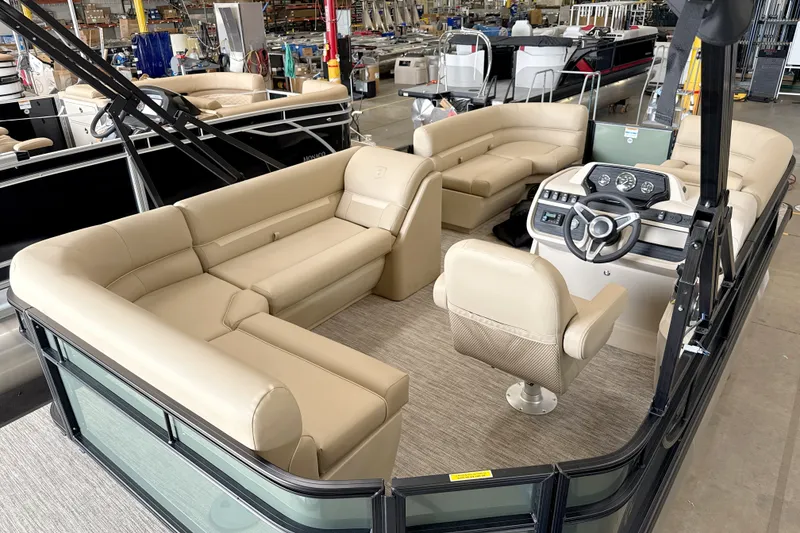 Slide: The Image of Luxurious 2027 Godfrey EX 1880 CX pontoon boat interior with beige seating and modern dashboard. - 1