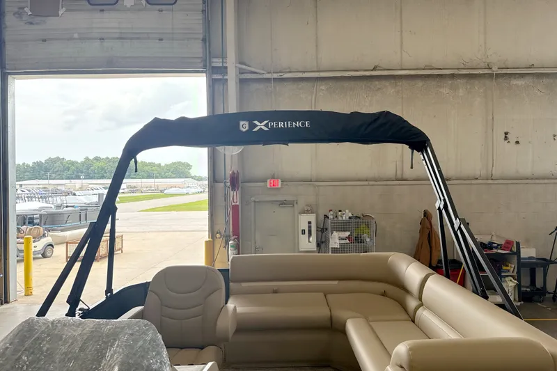 Slide: The Image of 2027 Godfrey EX 1880 CX pontoon boat with beige seating in a warehouse. - 3