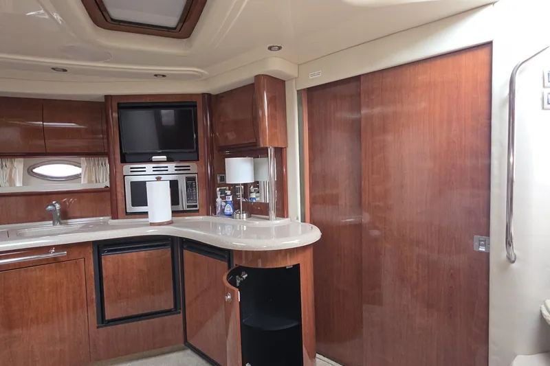 Slide: The Image of 2004 Sea Ray 420 Sundancer yacht interior with wood cabinetry and modern appliances. - 23