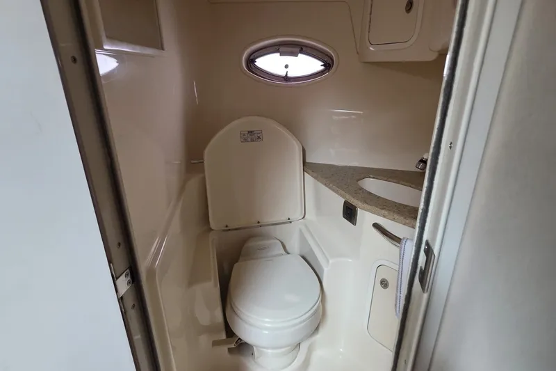 Slide: The Image of 2004 Sea Ray 420 Sundancer bathroom with toilet, sink, and porthole window. - 43