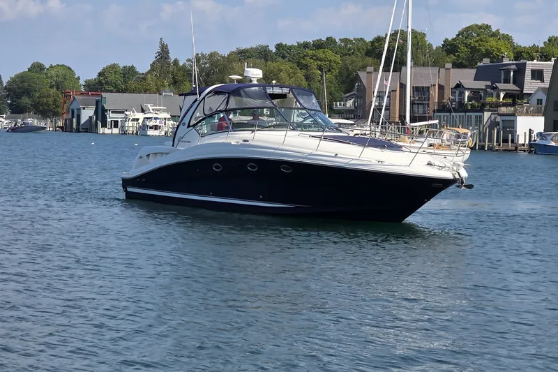 Slide: The Image of 2004 Sea Ray 420 Sundancer yacht cruising on a scenic waterfront. - 4