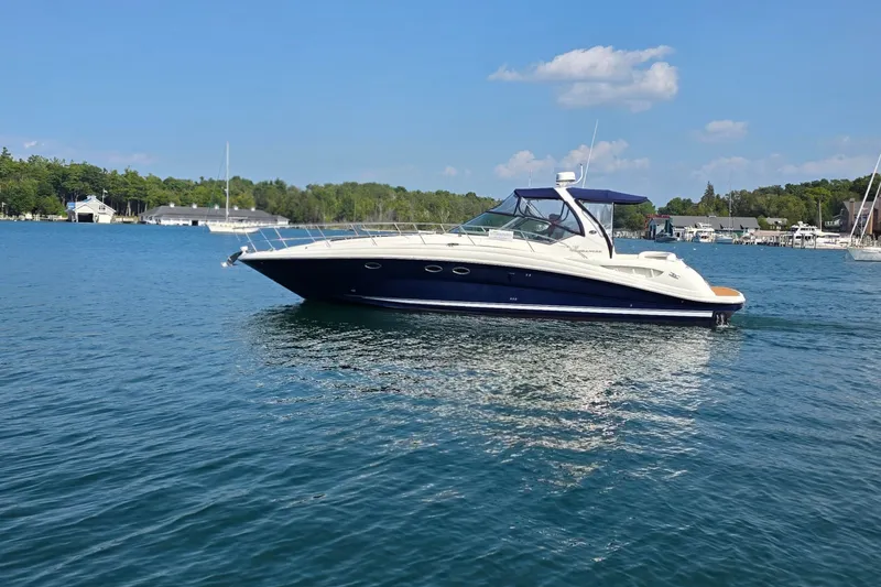 Slide: The Image of 2004 Sea Ray 420 Sundancer yacht on calm water, clear sky background. - 5