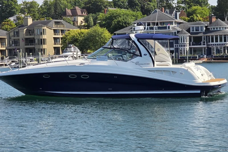 Slide: The Image of 2004 Sea Ray 420 Sundancer yacht docked near waterfront homes. - 2