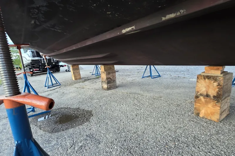 Slide: The Image of 2004 Sea Ray 420 Sundancer hull supported by blocks and stands in a boatyard. - 49
