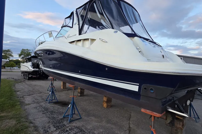 Slide: The Image of 2004 Sea Ray 420 Sundancer yacht on stands, blue and white hull, outdoor setting. - 9