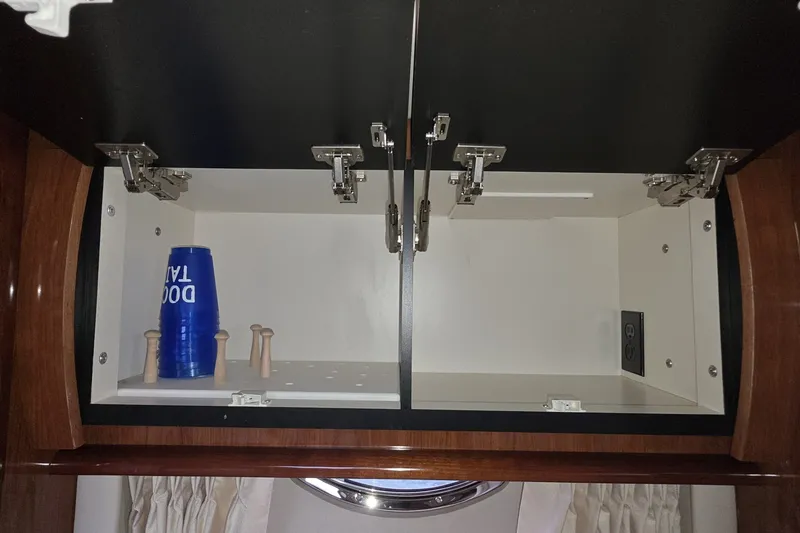 Slide: The Image of Open cabinet in 2004 Sea Ray 420 Sundancer yacht with blue cups and wooden pegs. - 27
