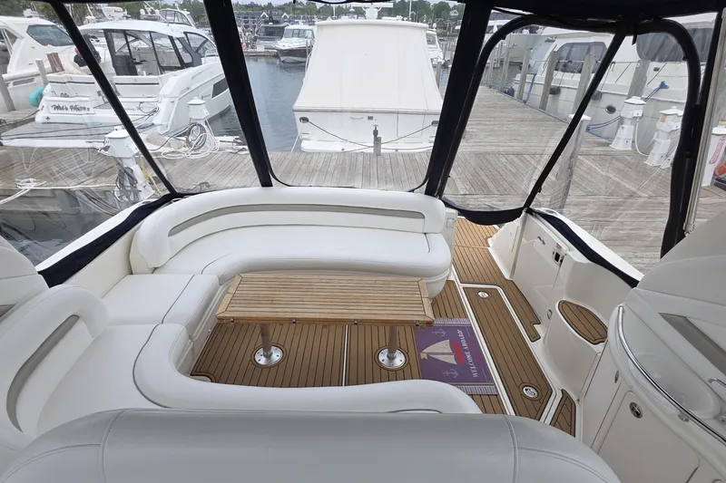 Slide: The Image of Luxurious 2004 Sea Ray 420 Sundancer yacht interior with white seating and wooden table. - 16