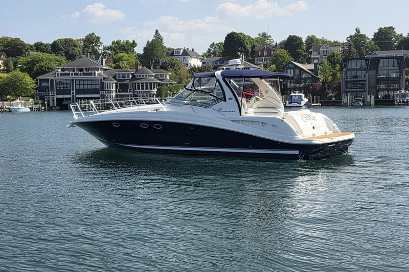 Slide: The Image of 2004 Sea Ray 420 Sundancer yacht on calm water near waterfront homes. - 3