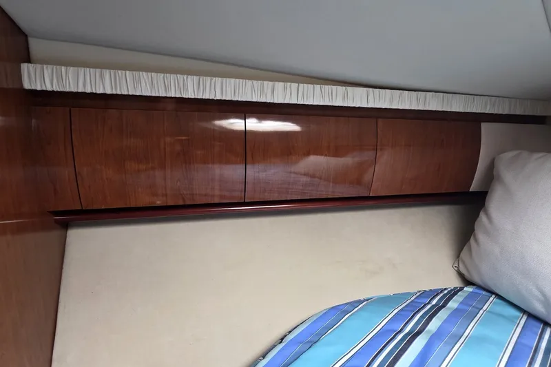 Slide: The Image of Interior cabin of 2004 Sea Ray 420 Sundancer with wooden cabinetry and striped bedding. - 38