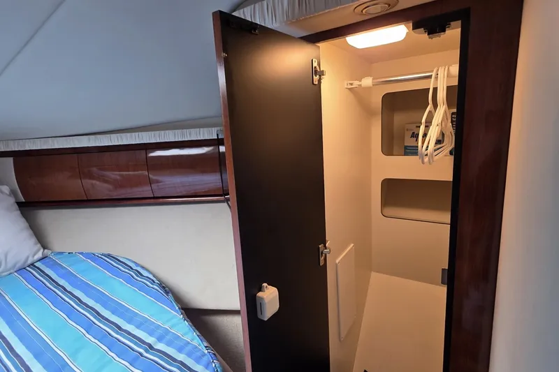 Slide: The Image of Interior cabin of 2004 Sea Ray 420 Sundancer with open closet and bed. - 37