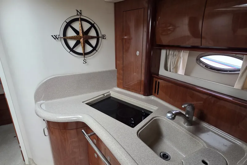 Slide: The Image of 2004 Sea Ray 420 Sundancer yacht kitchen with compass wall decor and modern amenities. - 36