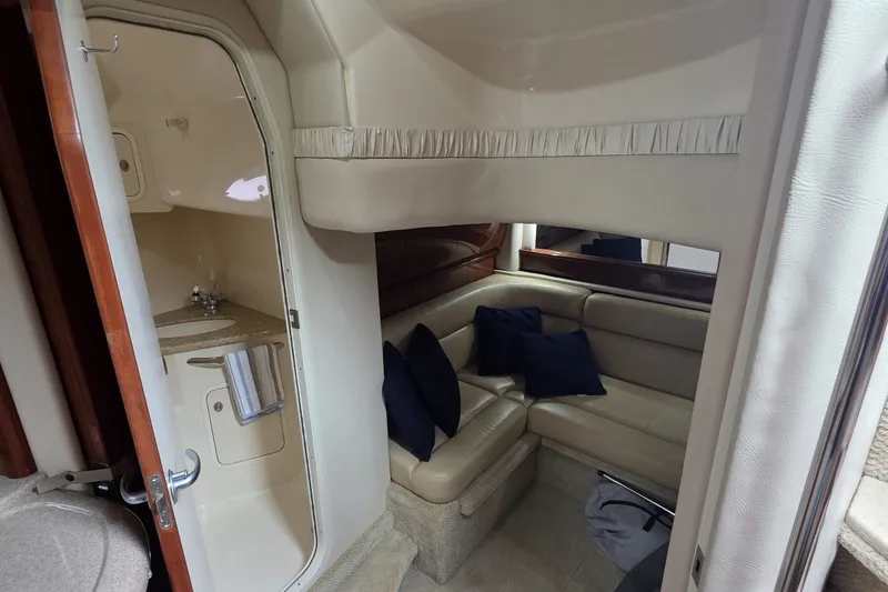 Slide: The Image of 2004 Sea Ray 420 Sundancer interior with beige seating and compact bathroom. - 42