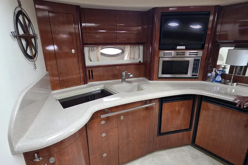 Slide: The Image of Luxurious 2004 Sea Ray 420 Sundancer yacht kitchen with wood cabinetry and modern appliances. - 35