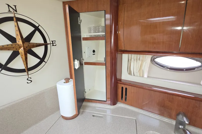 Slide: The Image of 2004 Sea Ray 420 Sundancer interior with compass decor and wooden cabinetry. - 24