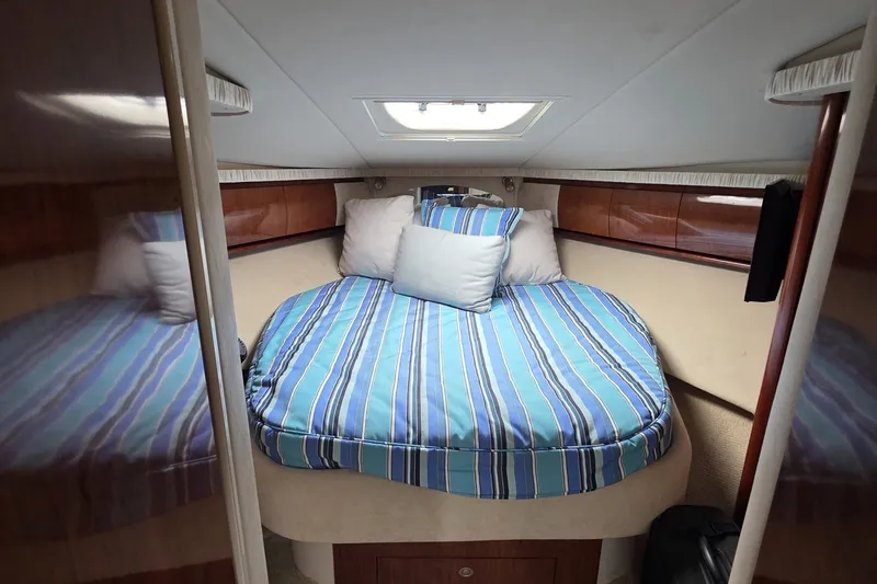 Slide: The Image of Luxurious cabin interior of 2004 Sea Ray 420 Sundancer with striped bedding. - 39