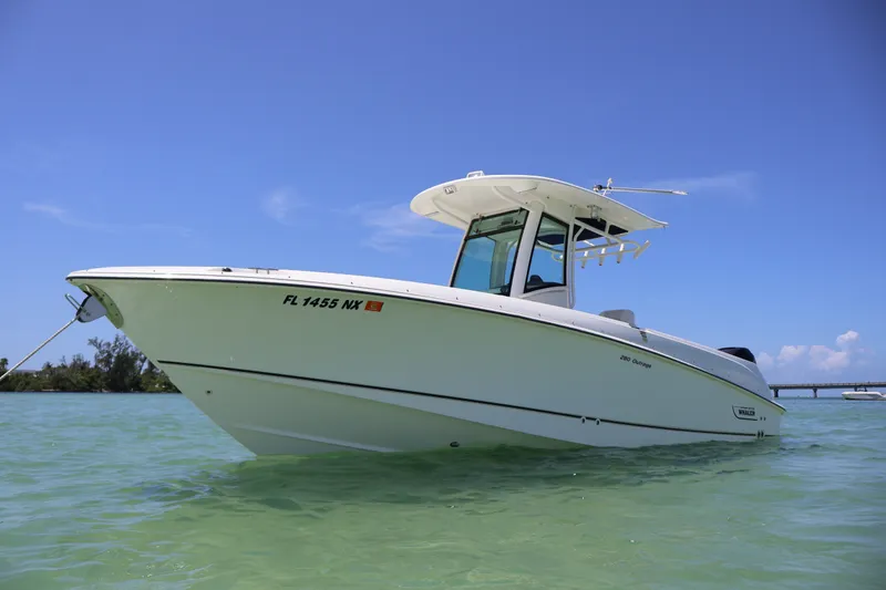 The Image of 2009 Boston Whaler 280 Outrage boat anchored in clear water under a blue sky. - 0