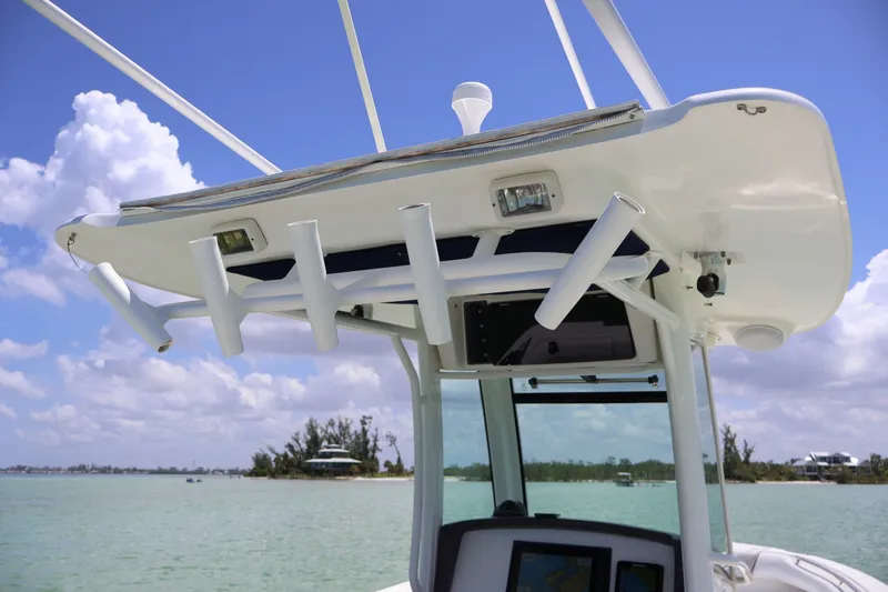 Slide: The Image of Boston Whaler 280 Outrage 2009 boat console with rod holders and electronics, under clear sky. - 12
