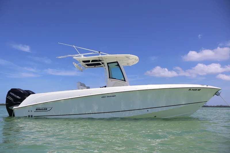 Slide: The Image of 2009 Boston Whaler 280 Outrage boat on calm water under clear blue sky. - 3