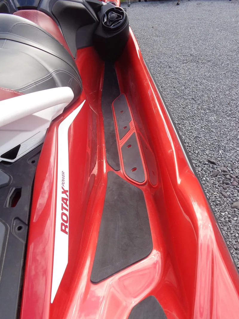 Slide: The Image of Close-up of a red Sea-Doo RXT-X 325 jet ski with black footrests and gray seat. - 16