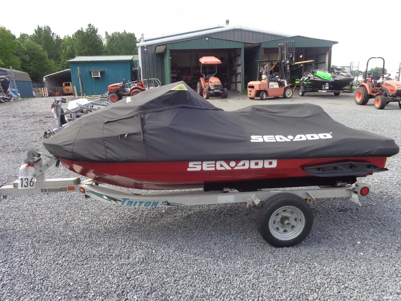 Slide: The Image of A 2024 Sea-Doo RXT-X 325 with cover on a trailer, surrounded by farm equipment. - 30