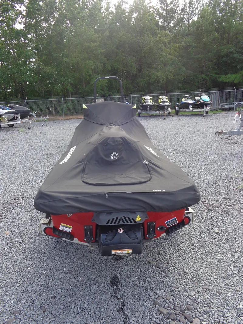 Slide: The Image of A 2024 Sea-Doo RXT-X 325 with a cover on a gravel lot. - 32