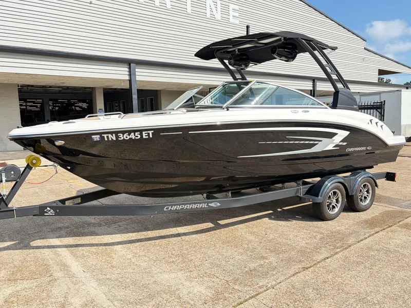 Slide: The Image of A 2021 Chaparral 23 SSi boat on a trailer in front of a building. - 2
