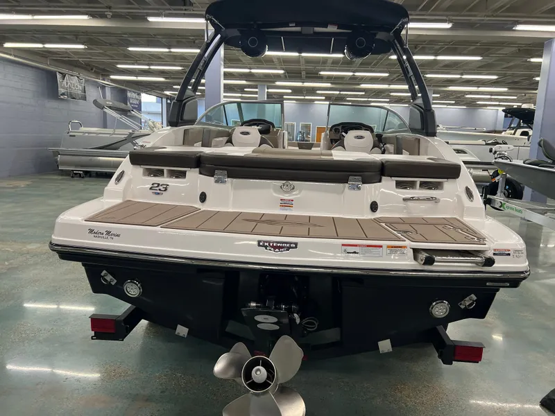 Slide: The Image of The image shows the rear of a 2021 Chaparral 23 SSi boat in a showroom. - 9