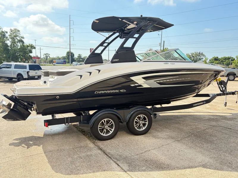 Slide: The Image of A 2021 Chaparral 23 SSi boat on a trailer, featuring a sleek design and black finish. - 4