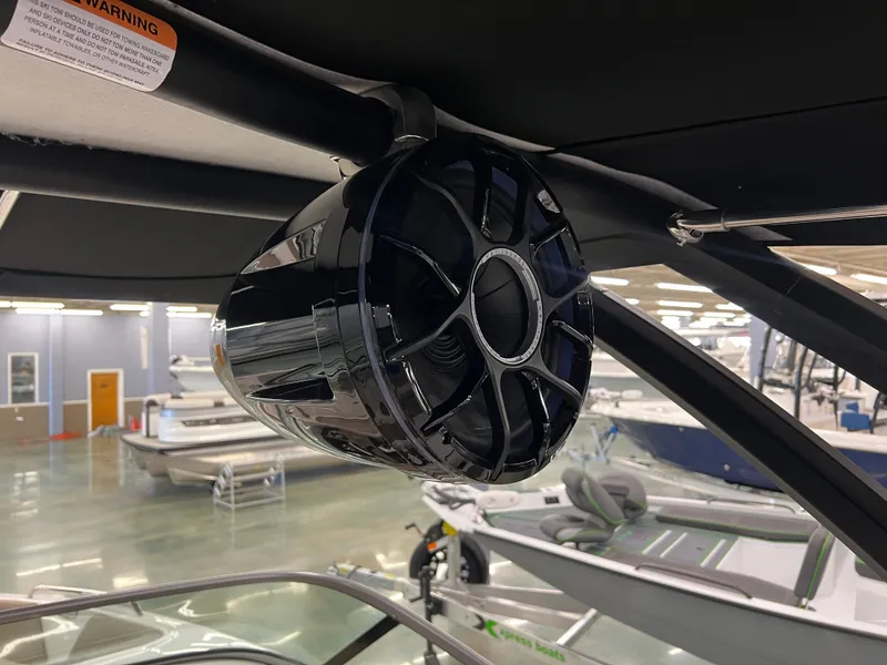 Slide: The Image of A black speaker is mounted on the ceiling of a boat. Other boats are visible in the background. - 18