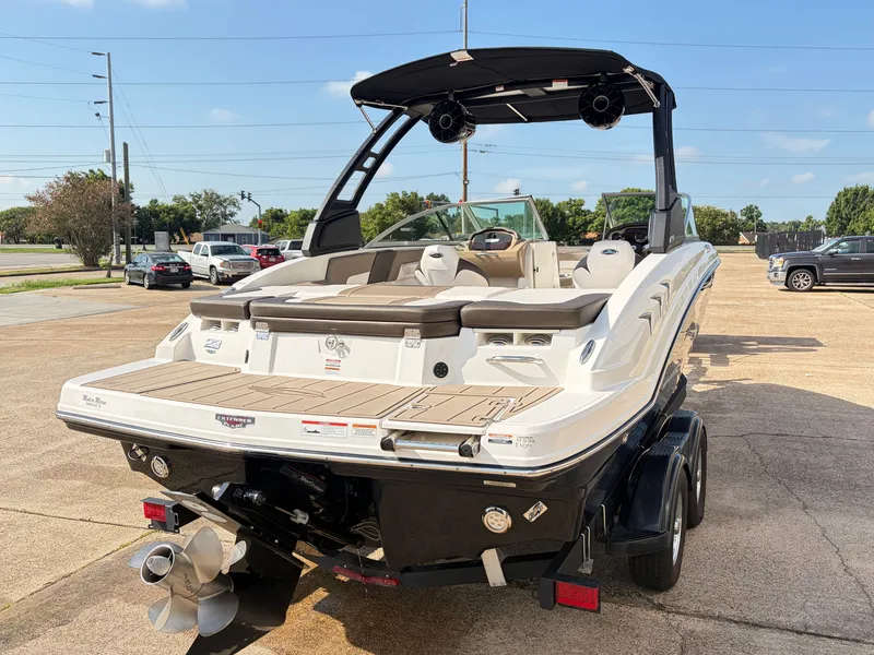 Slide: The Image of A 2021 Chaparral 23 SSi boat on a trailer, featuring a black Bimini top and outboard motor. - 5