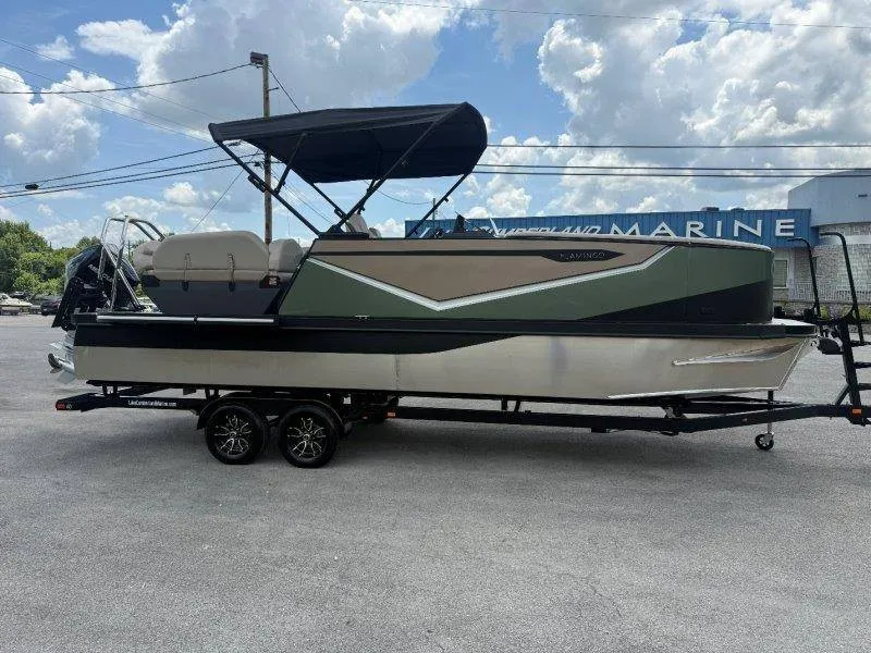 Slide: The Image of The image shows a 2027 Flamingo ROVE 245 boat on a trailer. It features a modern design with a black and green color scheme and a sunshade. - 23