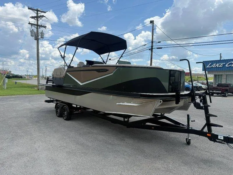 Slide: The Image of A 2027 Flamingo ROVE 245 on a trailer. It features a dark green and beige design. - 16