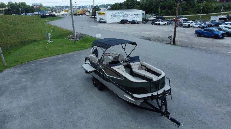 Slide: The Image of A 2027 Flamingo ROVE 245 boat on a trailer in a parking lot. It features a black canopy. - 14