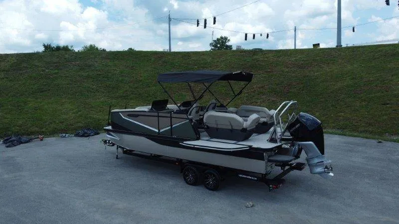 Slide: The Image of A modern pontoon boat with a black canopy sits on a trailer in a parking area. - 5