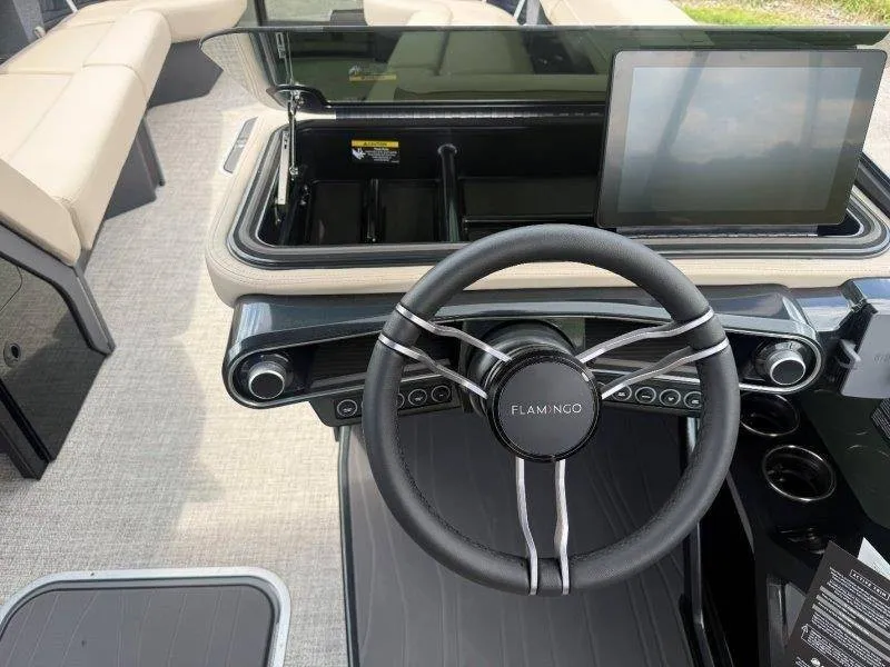 Slide: The Image of The image shows the cockpit of a Flamingo ROVE 245 boat with a modern steering wheel and screen. - 50